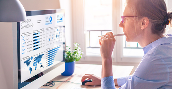 Businesswoman using business analytics or intelligence dashboard on computer screen (Demo)