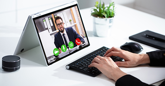 Cropped image of businesswoman using laptop at desk (Demo)