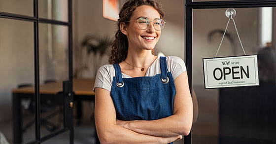 Small business owner standing at cafe entrance