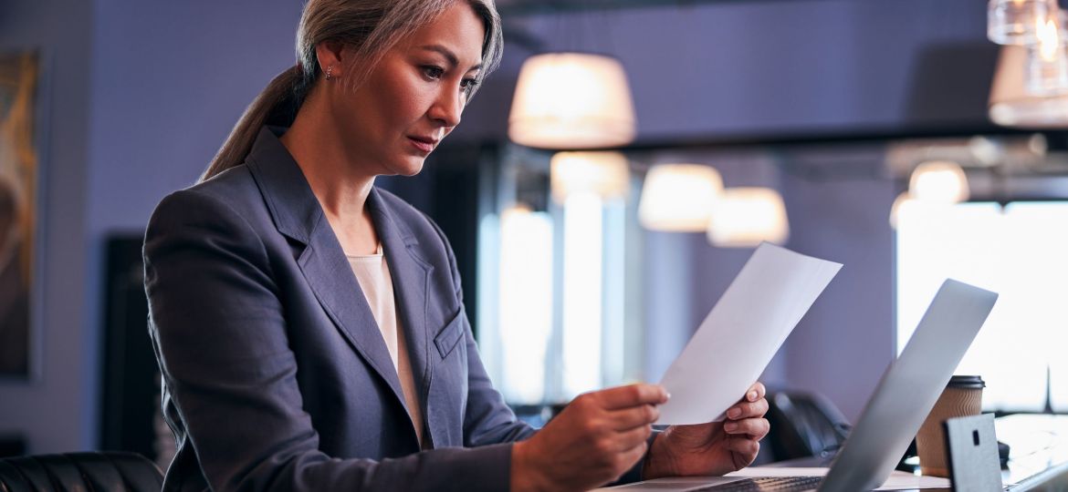 Beautiful businesswoman studying project papers at work