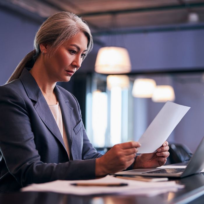 Beautiful businesswoman studying project papers at work